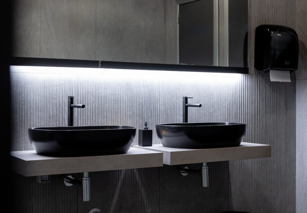 bagno elegante moderno nero e grigio minimal lavandini luci sofisticate specchio